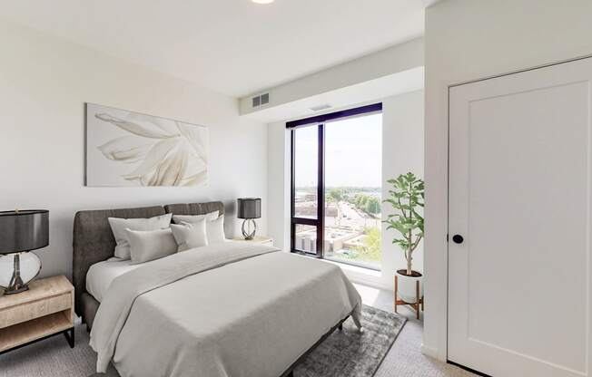 a white bedroom with a large bed and a door to a balcony