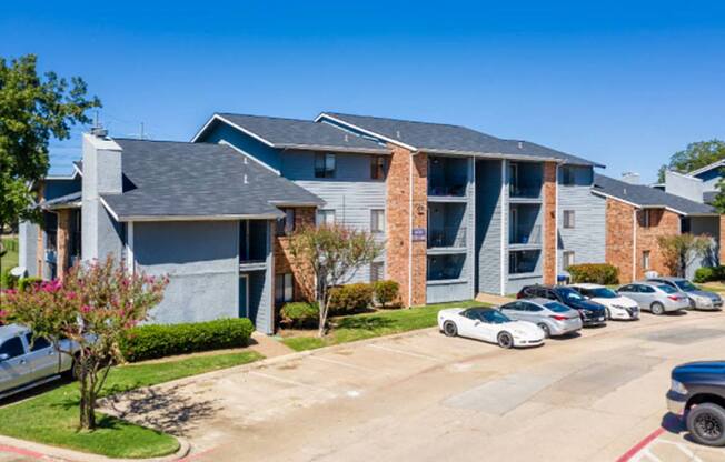 an apartment building with cars parked in front of it