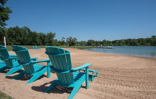 a group of blue chairs sitting on the beach