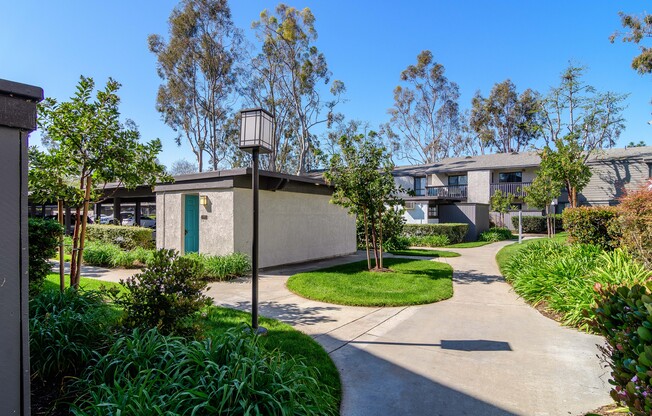 A sunny day in a residential area with a pathway and greenery.