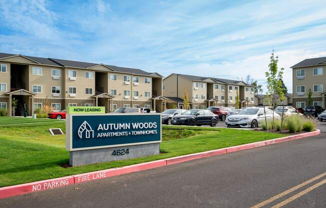 an exterior view of an apartment complex with cars in the parking lot