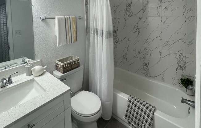 a white bathroom with a sink toilet and tub