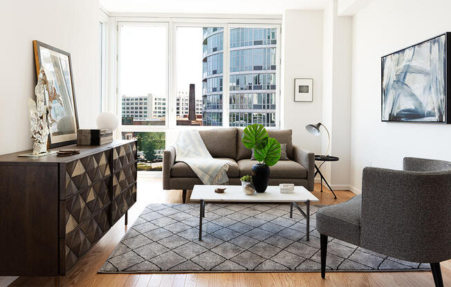 Living room with floor to ceiling windows, flex space, and hardwood floors in queens. 