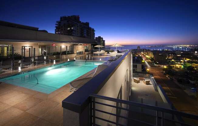 a view of a pool and a city at night