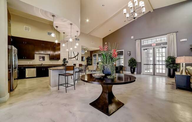 a large living room with a large chandelier and a round table with a vase