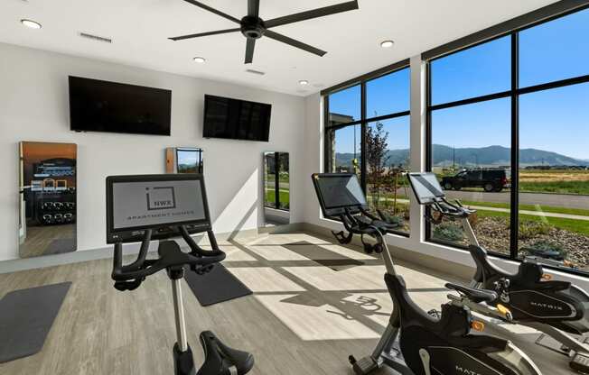 a home gym with exercise machines and a large window