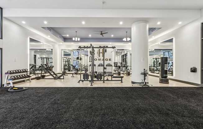 A spacious gym with a variety of equipment and mirrors on the walls.