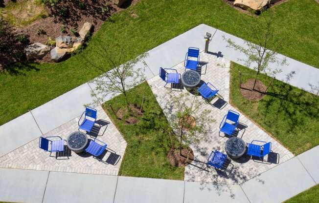 a patio with blue chairs and tables in a park at One Ten Apartments, Jersey City , NJ, 07310