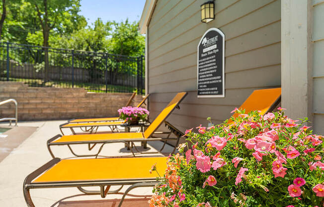 a patio with benches and flowers and a sign on a building