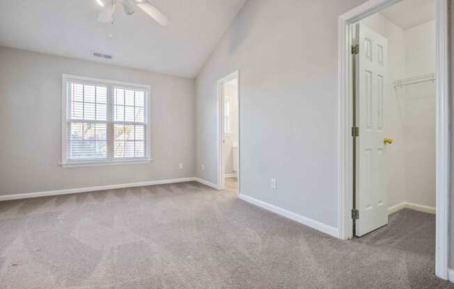 an empty living room with a white door and a window