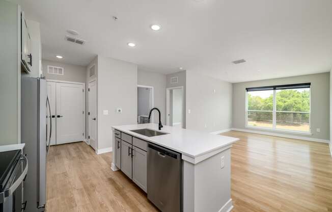 a white kitchen with a large island and stainless steel appliances