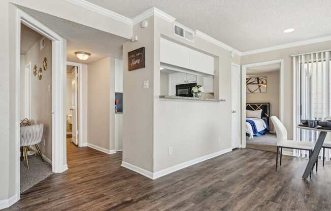 the living room and kitchen of a home with a hard wood floor