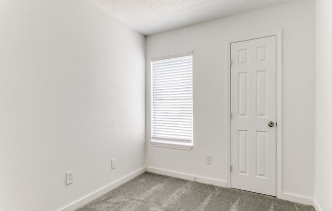an empty room with a door and a window