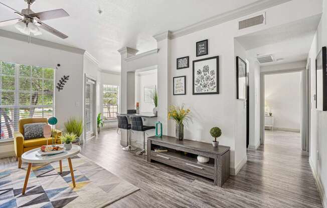 A living room with a yellow chair and a wooden coffee table.