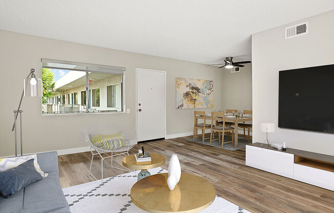 Hardwood floored living room with view of courtyard and dining room.