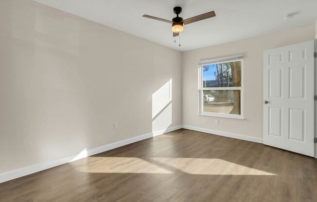 photo of a bedroom with hardwood floors and a ceiling fan