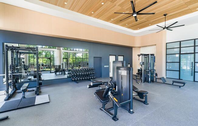 Spacious fitness studio with mirrored walls, strength equipment, and open training zones designed for balanced workouts and everyday performance.