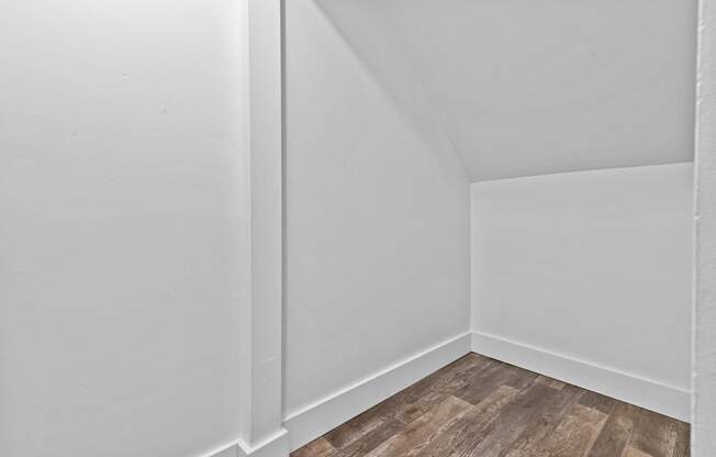 a small room with white walls and a wooden floor