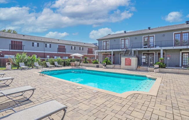 A swimming pool surrounded by lounge chairs at Magnolia apartments in Shreveport, LA