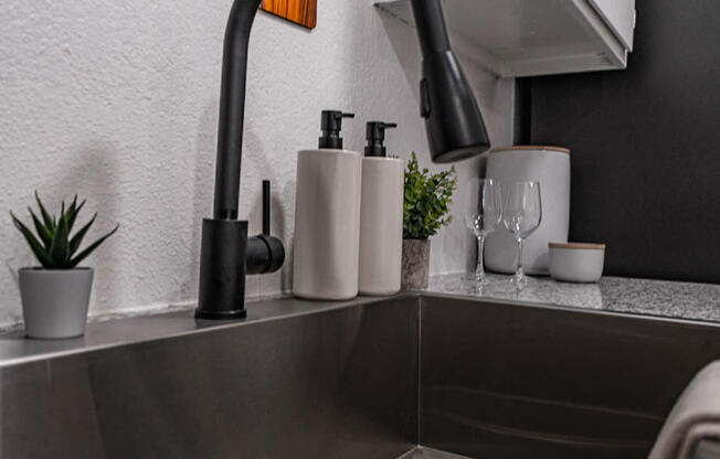 a kitchen sink with a faucet and a mirror above it