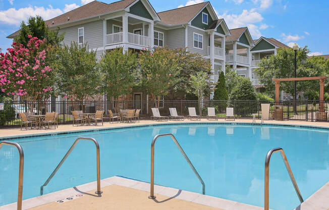 a swimming pool with a apartment building in the background