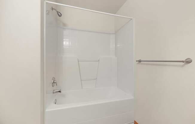 a bathroom with a bathtub and a towel rack