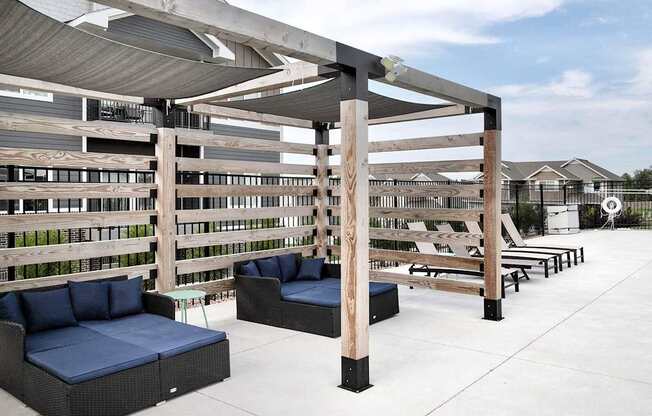A patio with a white floor and a wooden pergola.