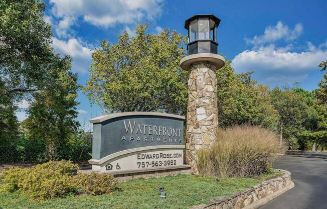 a sign for waterborn apartments in front of a road and trees