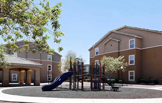 A playground with a slide in front of a building.
