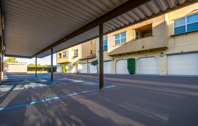 an empty parking lot in front of a building with white garage doors