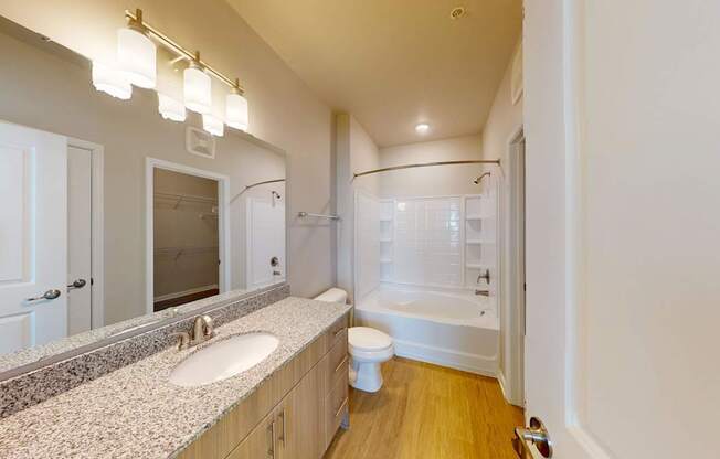 a bathroom with granite countertops and luxury vinyl flooring