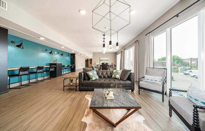 A modern living room with a black leather couch and a wooden coffee table.