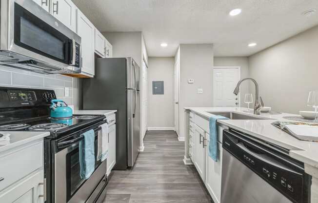 an empty kitchen with white cabinets and stainless steel appliances