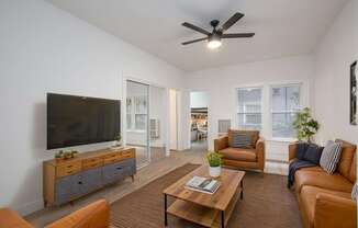 A living room with a brown sofa, a wooden coffee table, and a flat-screen TV at Westmore Manor Apartments, California, 90020