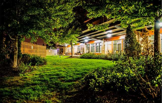 a backyard at night with lush green grass and trees at The Lofts at Elk Terminal, Buffalo, NY, New York