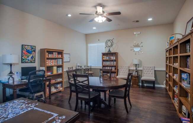 a living room with a dining room table and bookshelves