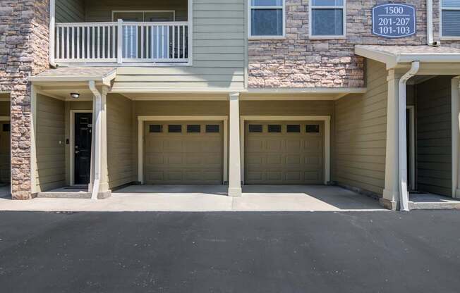 A building with a balcony and garage doors.