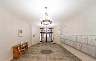 a long hallway with rows of lockers and a chandelier