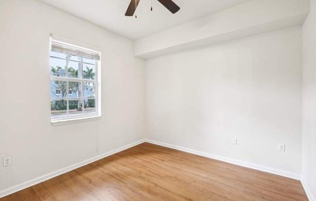 A room with a window and a ceiling fan.