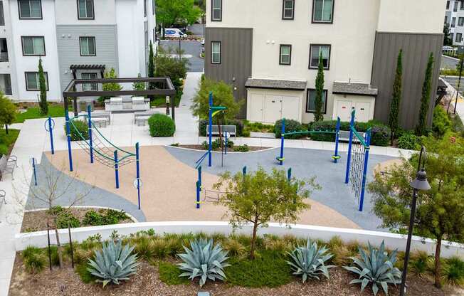 A playground with a blue swing set and a play structure.