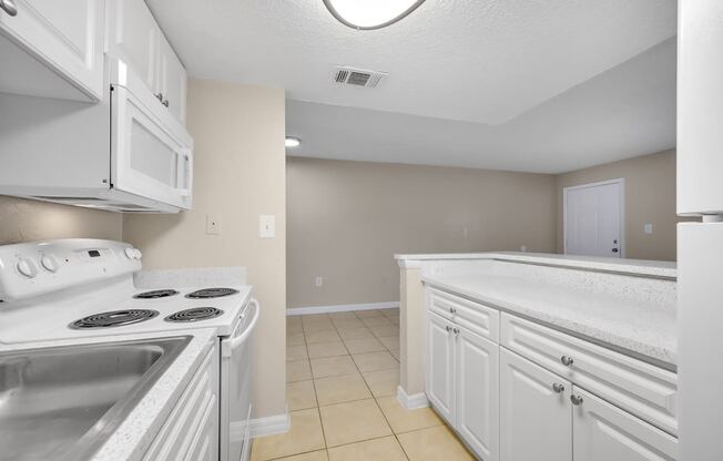 a kitchen with white cabinets and appliances and a white counter top