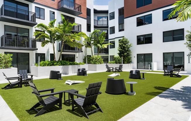 Central courtyard with Adirondack seating, outdoor games, and palm-framed gathering areas designed for neighborly connection.