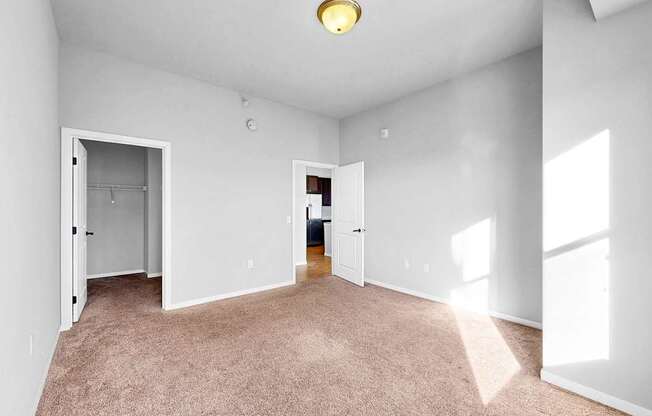 A room with white walls and carpeted floor with a light on.