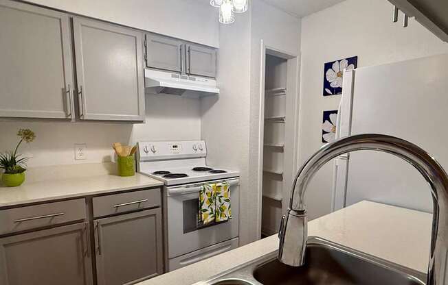 A kitchen with a stove, oven, and sink.