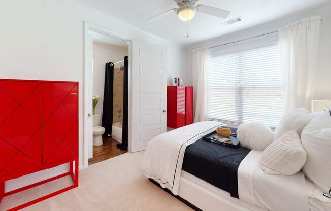 a bedroom with a red dresser in the corner of the room