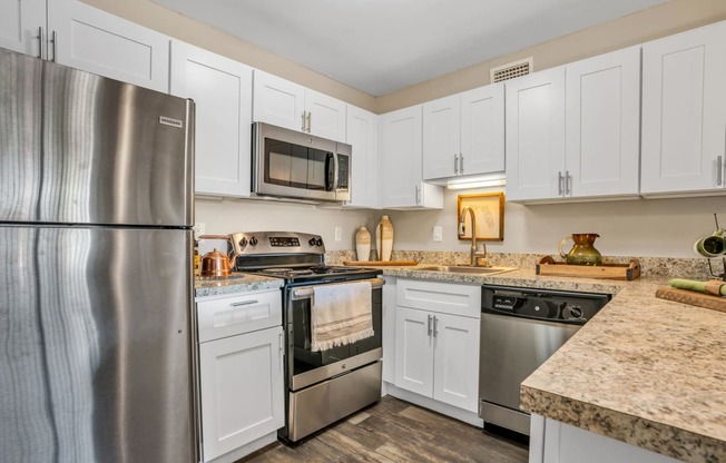 a kitchen with white cabinets and stainless steel appliances