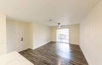 A spacious room with wooden flooring and a white sofa.