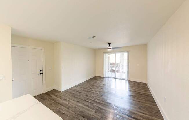 A spacious room with wooden flooring and a white sofa.