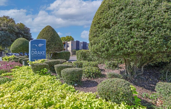 Green bushes surround a "The Drakes Apartments" sign at The Drake in Bossier City, LA