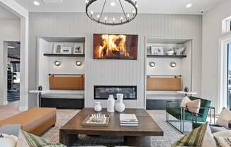 a cozy clubhouse with furnishings, decor, and a fireplace playing on the TV screen